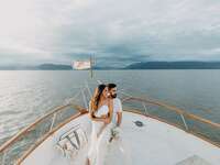 Bride and groom sitting on boat at destination wedding