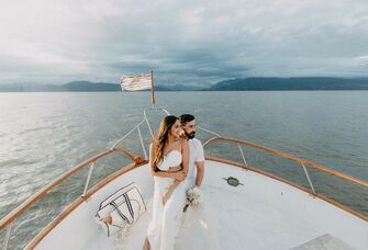 Bride and groom sitting on boat at destination wedding