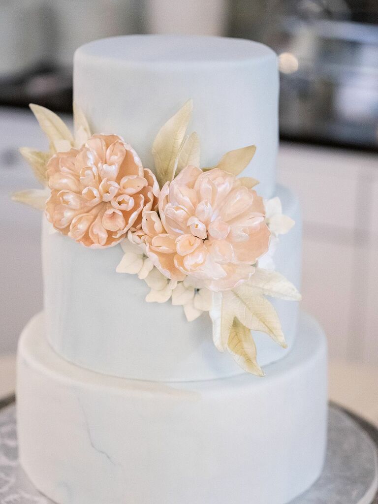 blue marbled wedding cake with pink sugar flowers decorated with iridescent petal dust