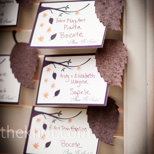 Escort cards with plantable wildflower seeds pressed into the shape of a leaf were displayed in the slats of an old wooden door.