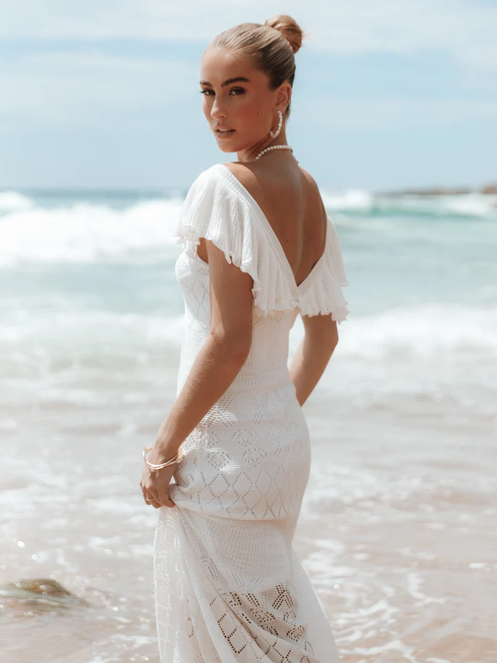 A model wears this gorgeous white lace gown with a low V-neck back.