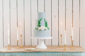 Blue-Gray Tiered Wedding Cake with Elegant Laurel Wreath Design