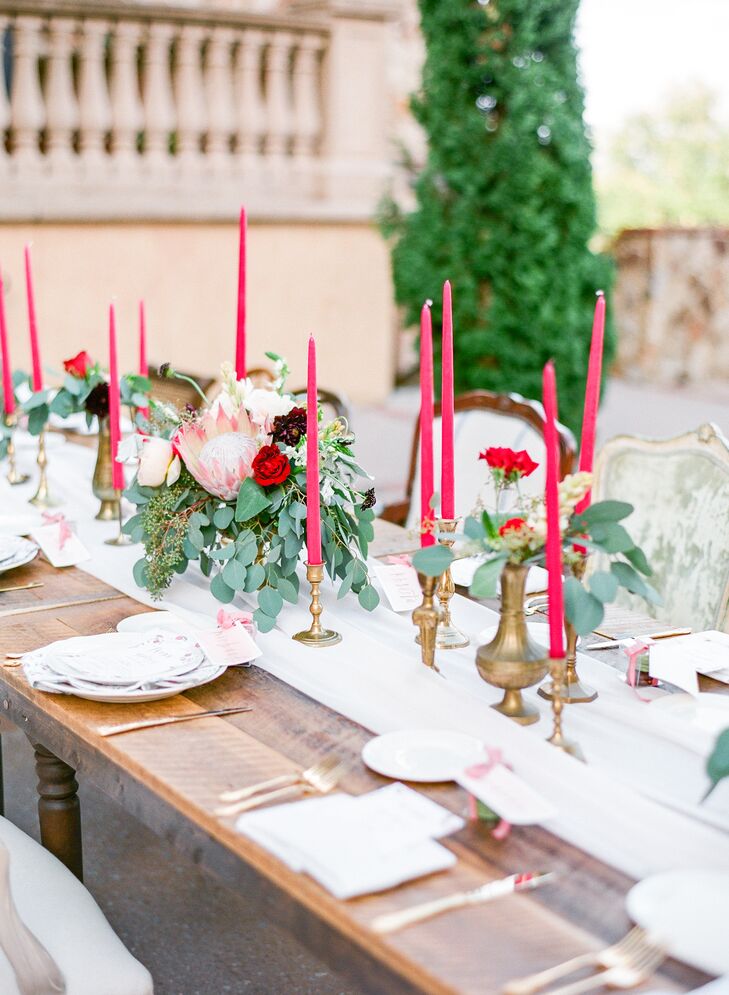 Each was exposed wood table was accented with mixed vintage chairs in various hues and styles, gold flatware, romantic low floral centerpieces and 13 cranberry candlesticks with brass bases. “Another thing we wanted to incorporate was the number 13. We found out I was pregnant on 10/13/12, got legally married on 10/13/13 and had our wedding on 10/13/14,” says Michelle.