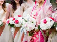 Bridesmaids and a bride holding white and pink bouquets.