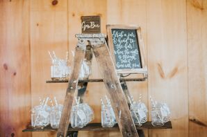 Mason Jars with Paper Straws Displayed on Rustic Ladder
