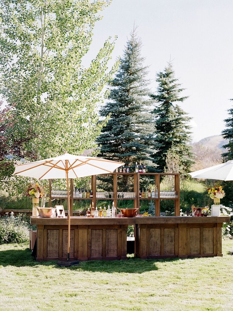 Wooden bar space at an outdoor wedding reception.
