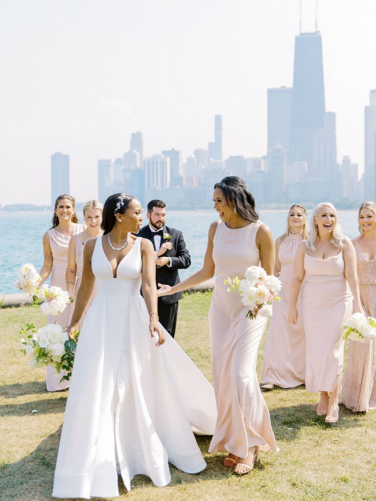Bride pictured with bridesmaids wearing blush pink dresses. 