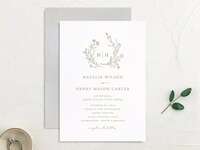 Monogram framed by greenery above event details with classic gray type on white background