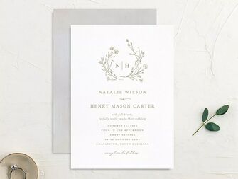 Monogram framed by greenery above event details with classic gray type on white background