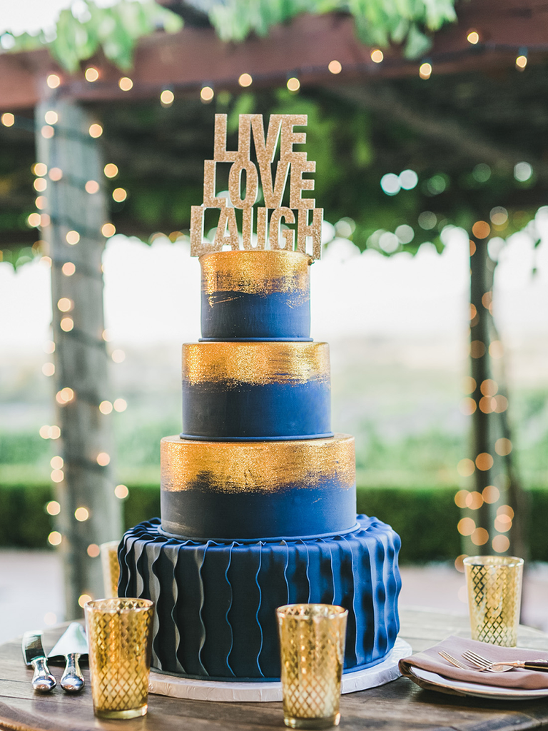 A navy fondant wedding cake with bright gold brushed tiers