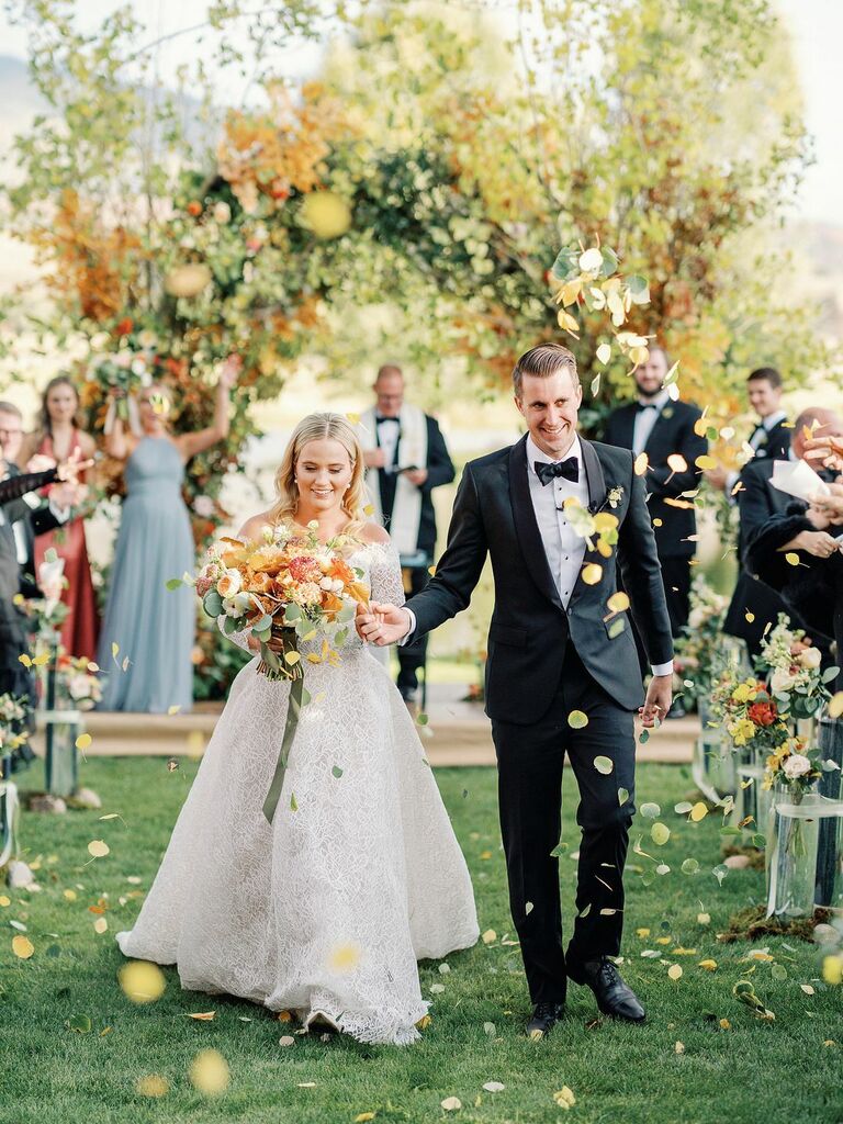 Guests throw leaves for the wedding exit toss. 