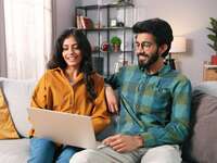 Couple using laptop at home