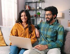 Couple using laptop at home