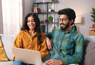 Couple using laptop at home
