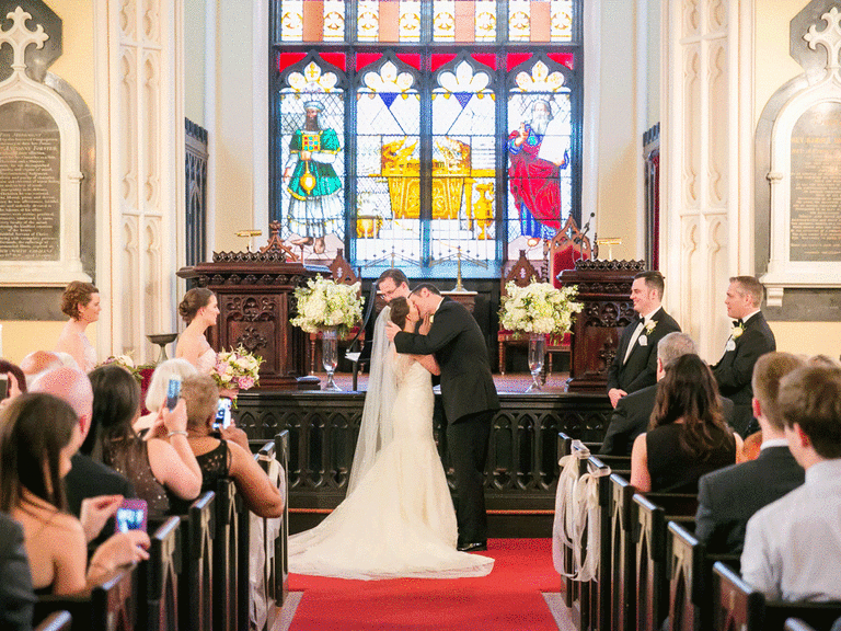 Bride and groom have their first kiss during Unitarian Universalist ceremony order for wedding.