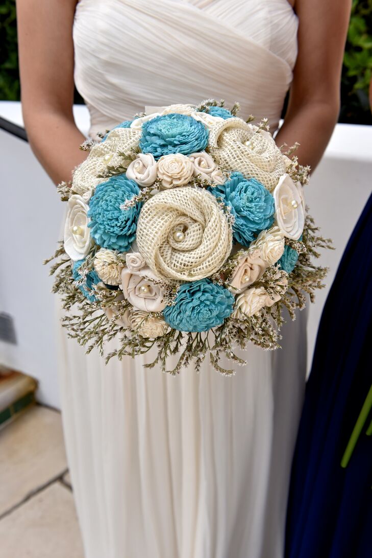 Julie held a round bouquet filled with blue and ivory flowers made of wood and fabric, accented with beads in the center. "I carried a bouquet of fabric and balsa wood flowers that was embellished with pearls, handmade by TheSunnyBee on Etsy."