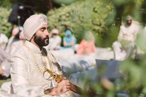 Sikh Groom in White Sherwani With a Turban and Sword at Ceremony