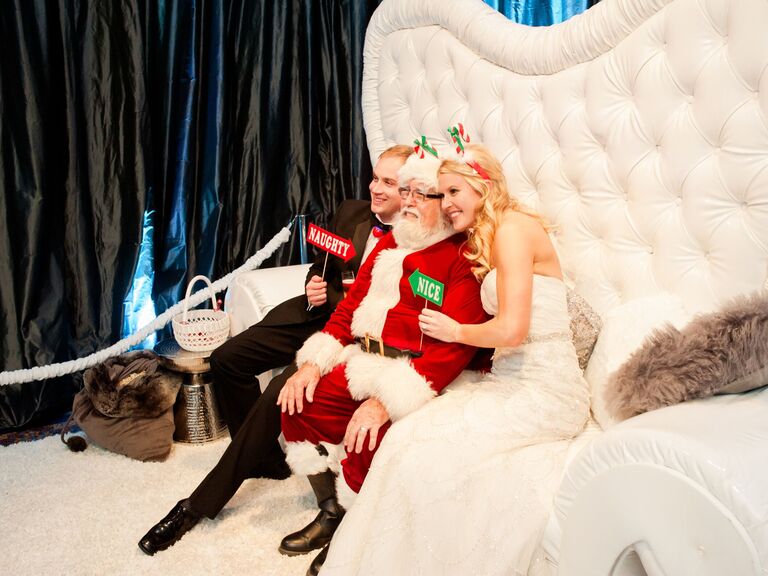 Couple poses in a Christmas-themed photo booth. 