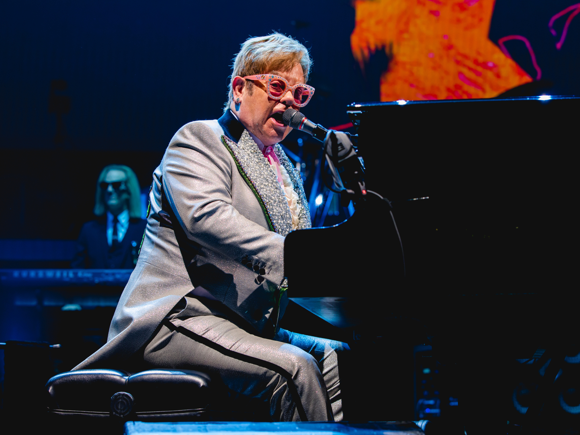 Elton John performing on stage at piano