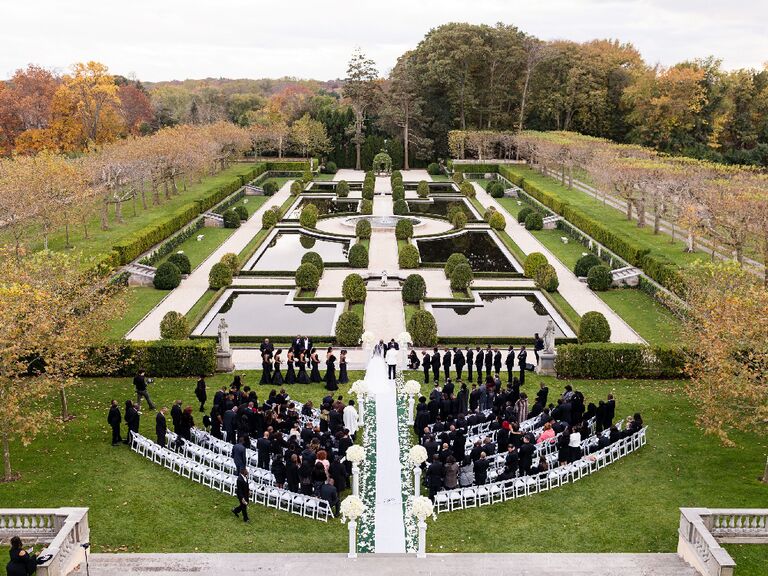 Guests in black-tie dress code at outdoor garden wedding ceremony