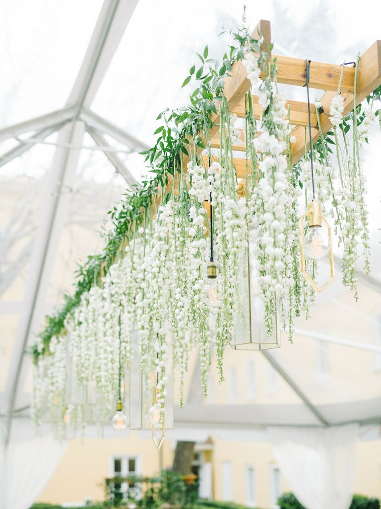 wooden ladder hanging above wedding table decorated with white flowers and gold glass lanterns
