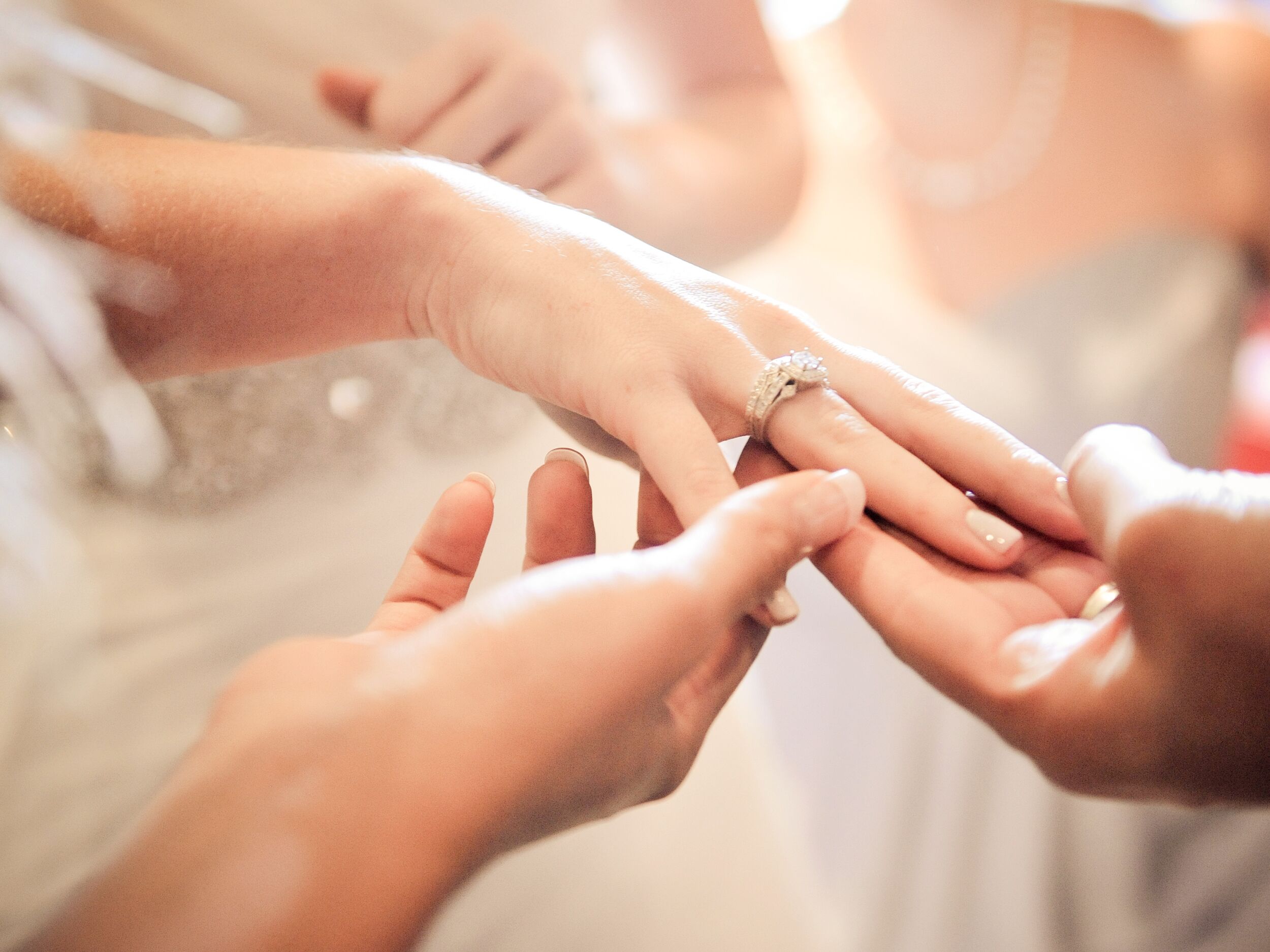 Wedding guests admiring bride's engagement ring