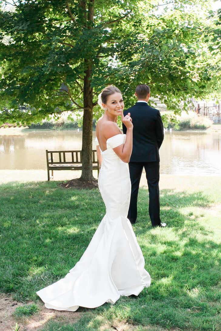 Drawing inspiration from the wedding’s fusion of laid-back and elegant styles, Rebecca opted for a simple, chic Kelly Faetanini gown. The silk chiffon dress featured a mermaid-style silhouette with a low-cut back and off-the-shoulder neckline, as well as fabric-covered buttons running down the back. “Words can hardly describe the feeling as I walked down the aisle toward the man of my dreams with my dad by my side, veil blowing in the breeze and the sun shinning through the trees behind us, all in my backyard. It was simply magical,” Rebecca says.