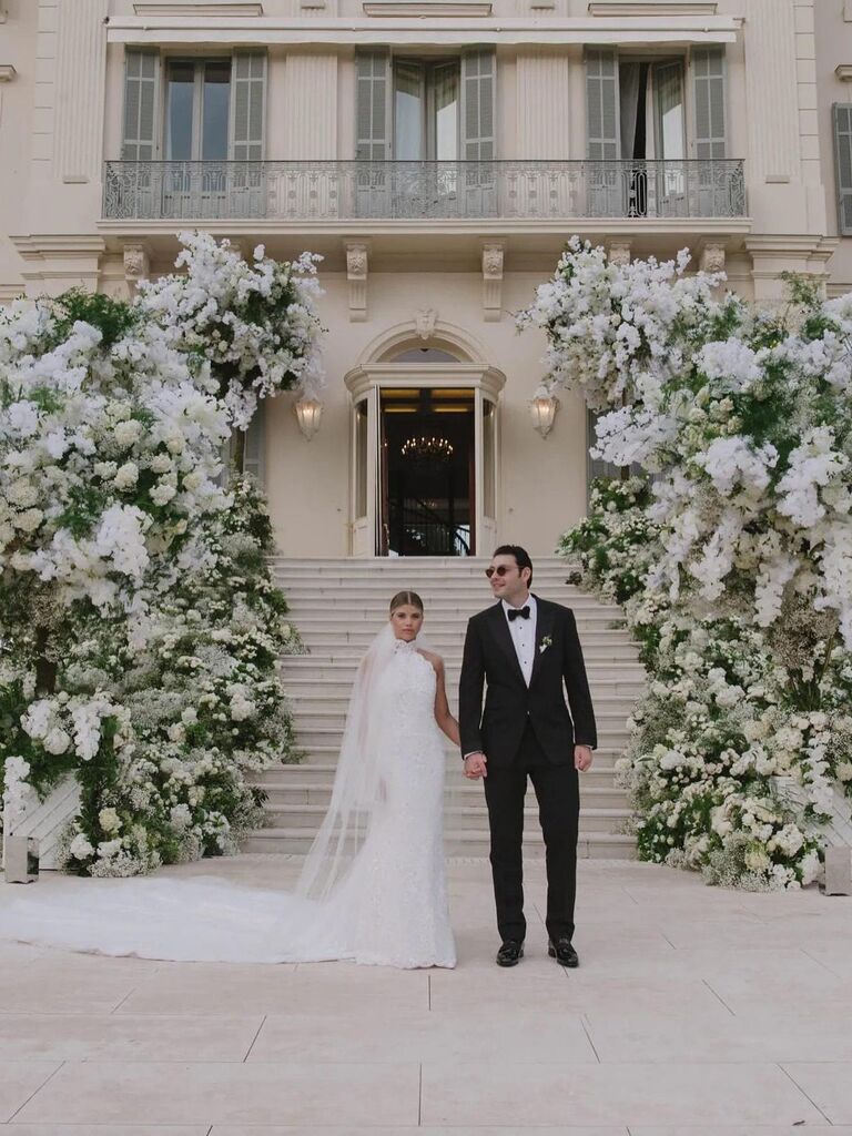 Sofia Richie Grainge and Elliot Grainge standing in front of wedding venue