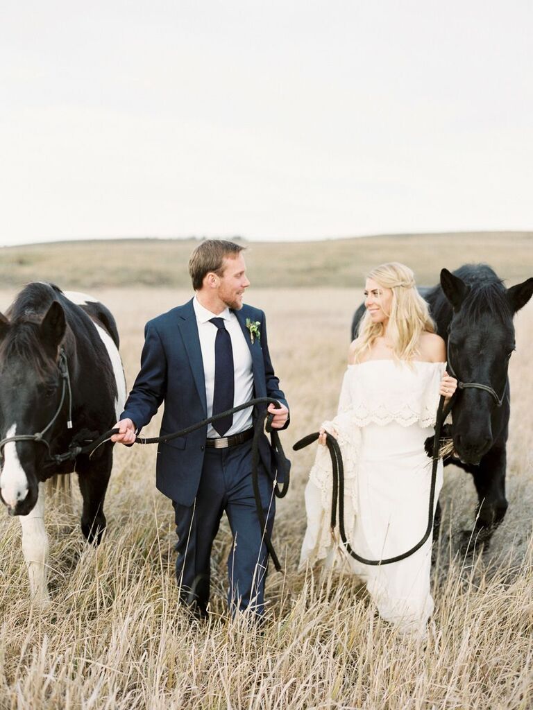 bride and groom walking with horses