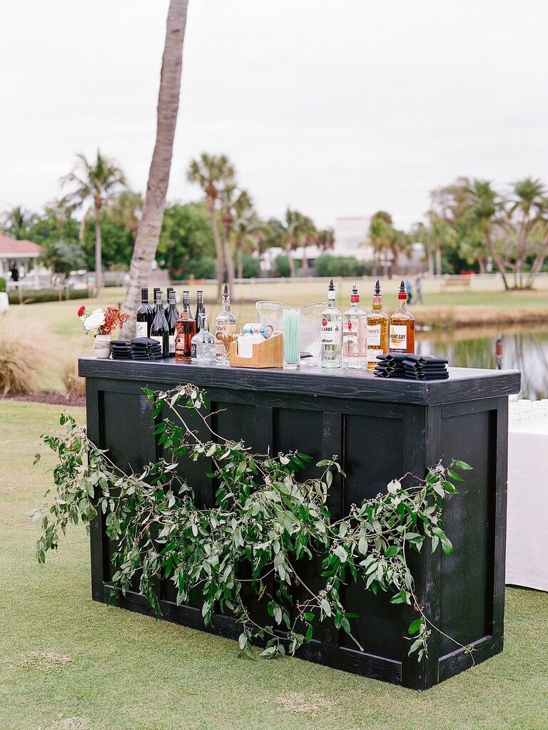 Black wooden bar top with greenery for outdoor wedding reception space