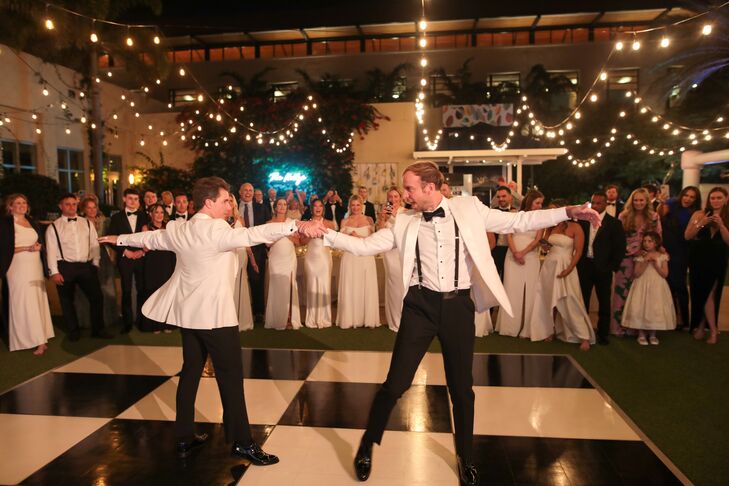 Grooms Performing Choreographed First Dance in White-and-Black Tuxedos on Checkered Dance Floor