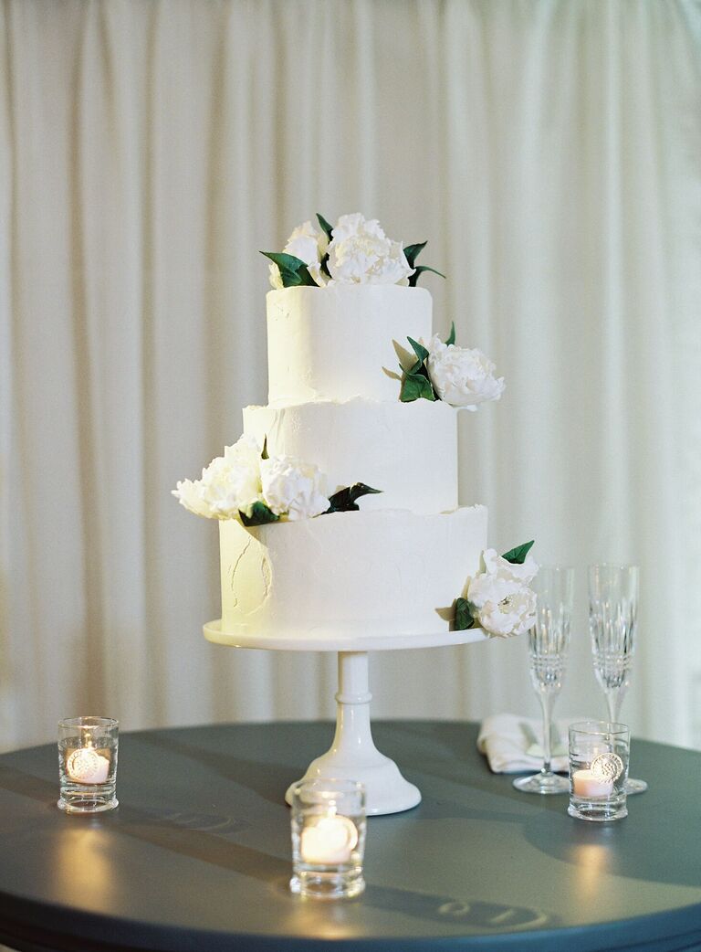 White three-tier wedding cake with white cake stand