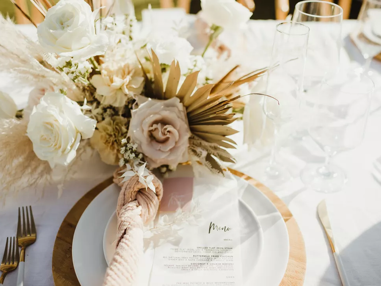 A gorgeous boho table arrangement of dried flowers and fresh roses.