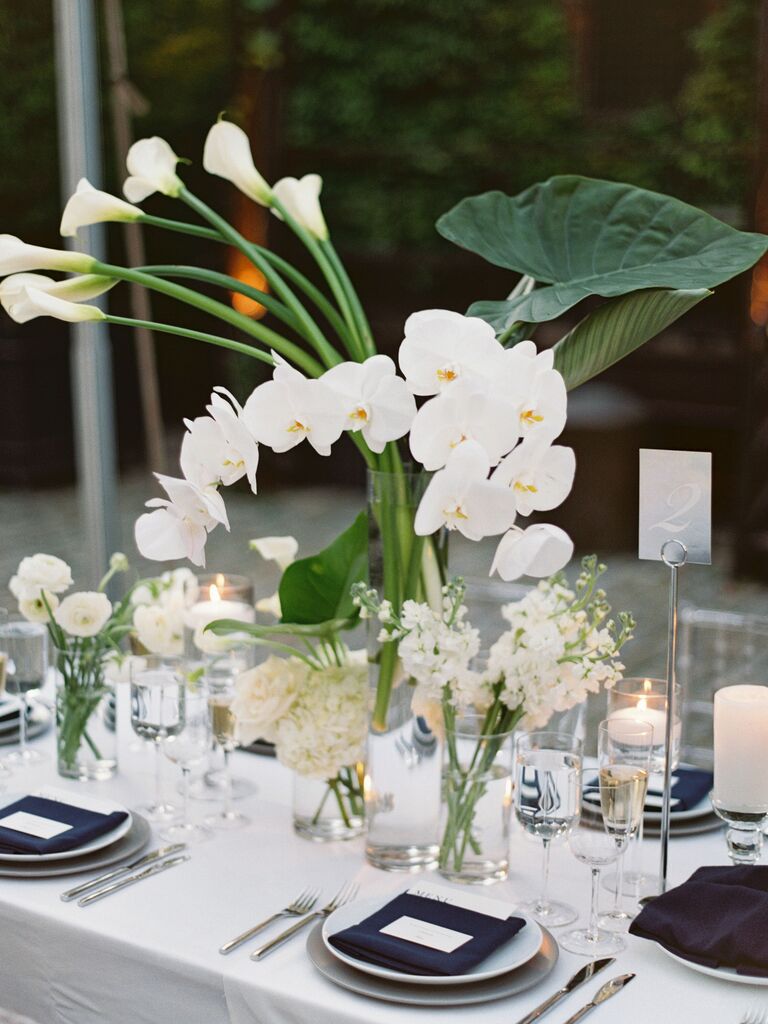 modern wedding tablescape with white phalaenopsis orchid and calla lily centerpieces with navy blue napkins