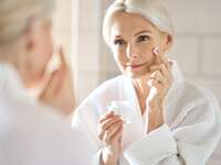 Mature woman applying face cream
