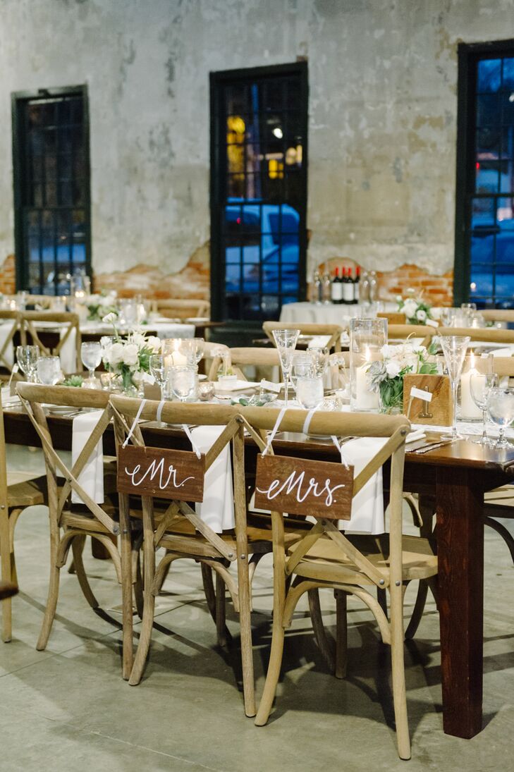 Corinne and John sat at their seats at long wooden farm tables, marked with wooden signs that read "Mr." and "Mrs." on the backs.They sat surrounded by their wedding party at the reception at Mount Washington Mill Dye House in Baltimore, Maryland.