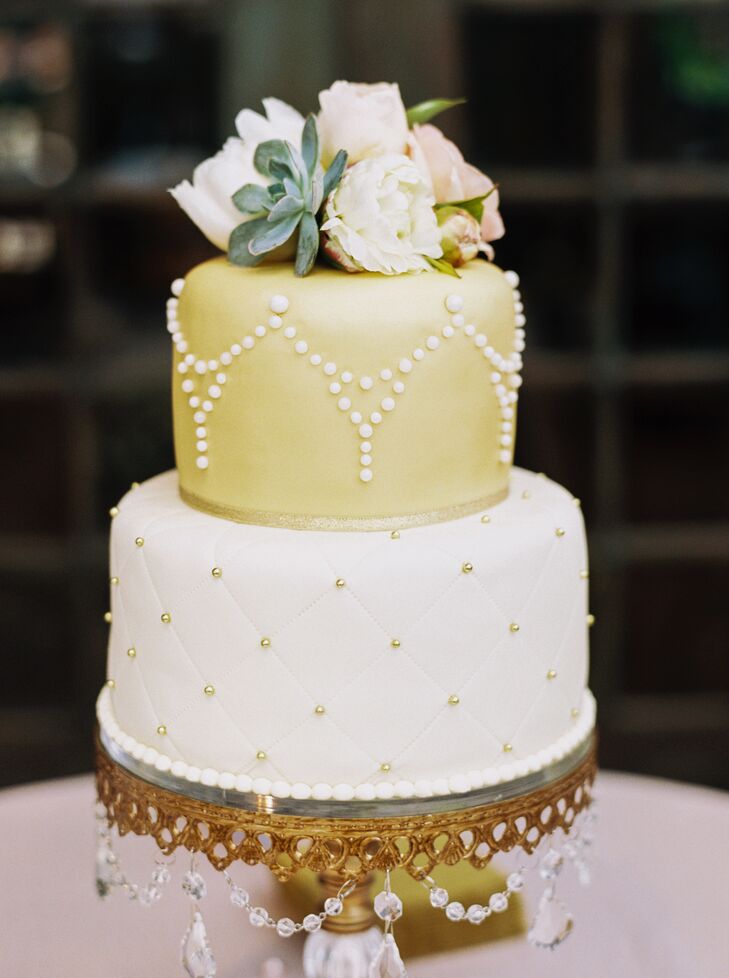 This two-tier wedding cake totally captured the boho chic wedding style, complete with fresh ivory and blush flowers and succulents on top to tie in the garden setting. The bottom tier had quilting with metallic gold dot accents, and the top tier had draped, pearly dots on gold fondant.