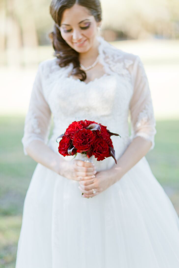 Designed by Windermere Flowers and Gifts, Marie's red and burgundy bouquet complemented her gorgeous ball gown and their venue’s natural beauty.  Red garden roses and burgundy calla lilies filled the arrangement as white lace gathered its stems.