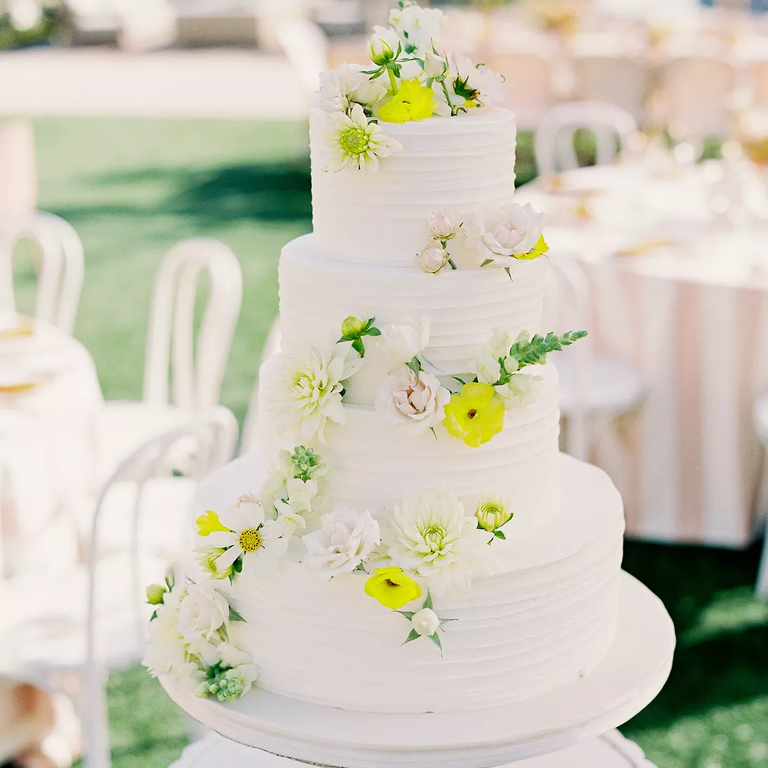 White wedding cake with yellow and white flowers