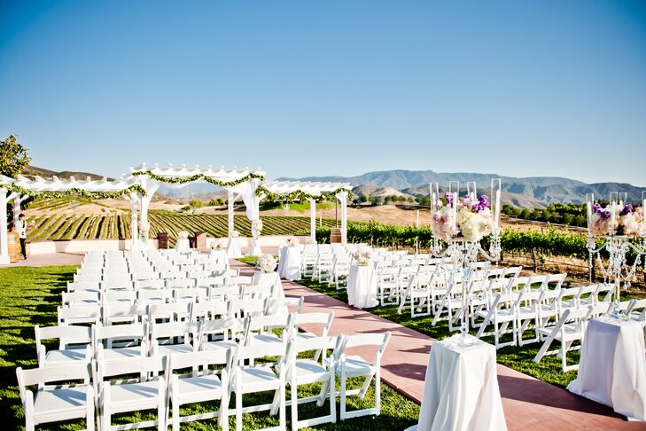 The ceremony took place on the lawn at Leoness Cellars in Temecula, California. Rows of white folding chairs were set up to face the altar, which was under the white wooden pergola that had a backdrop of the vineyards and mountains.