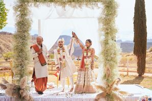 Indian Groom in White Sherwani, Bride in Red-and-Gold Lehenga Under Mandap