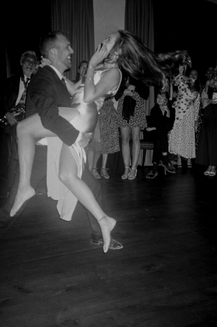 Black and White Photo of Bride and Groom Dancing a Samba at Wedding Reception