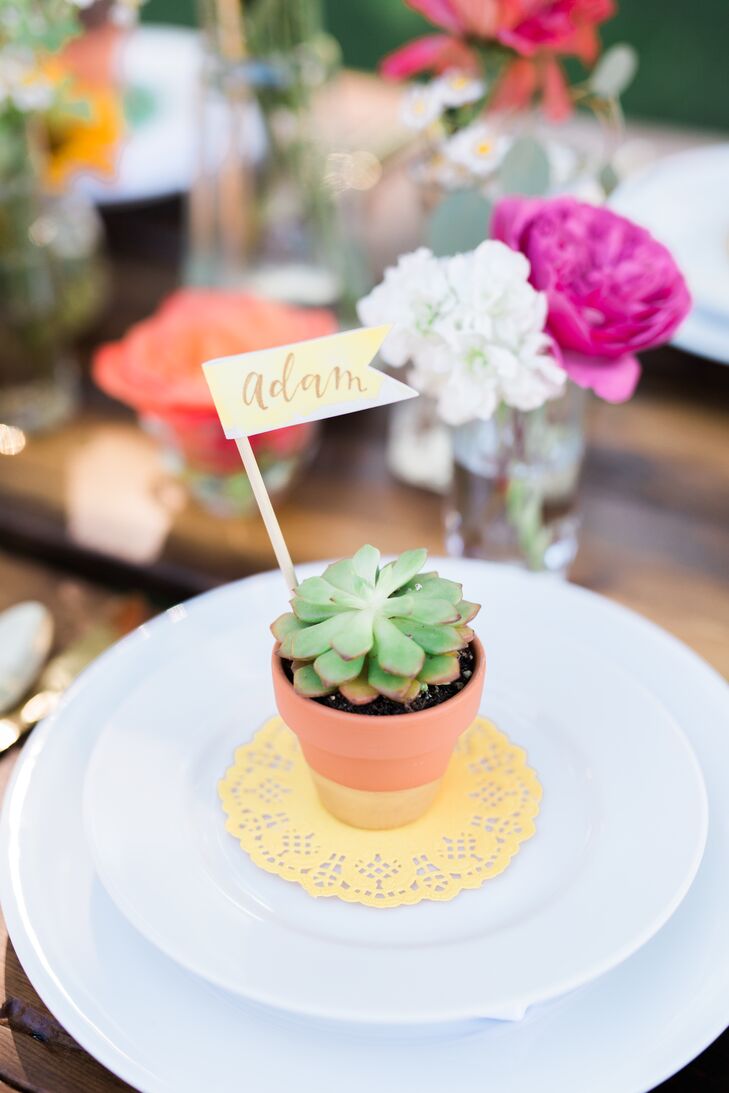 "Place cards for guests were potted succulents in hand-painted pots and little watercolored and hand-lettered flags, which were also designed to be gifts to the guests," Devin says.