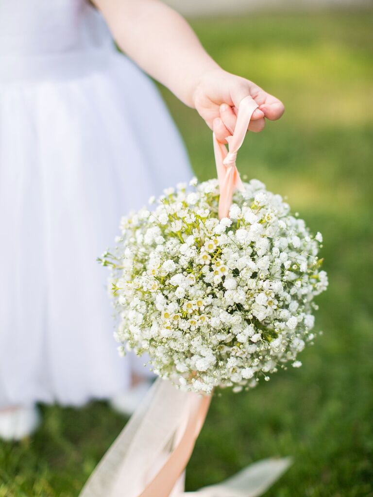 flower girl carrying pomander bouquet made of baby's breath
