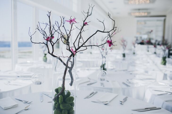 Tall vases with branches, moss balls, hanging candles and orchids offset the tall ceiling of the reception space.