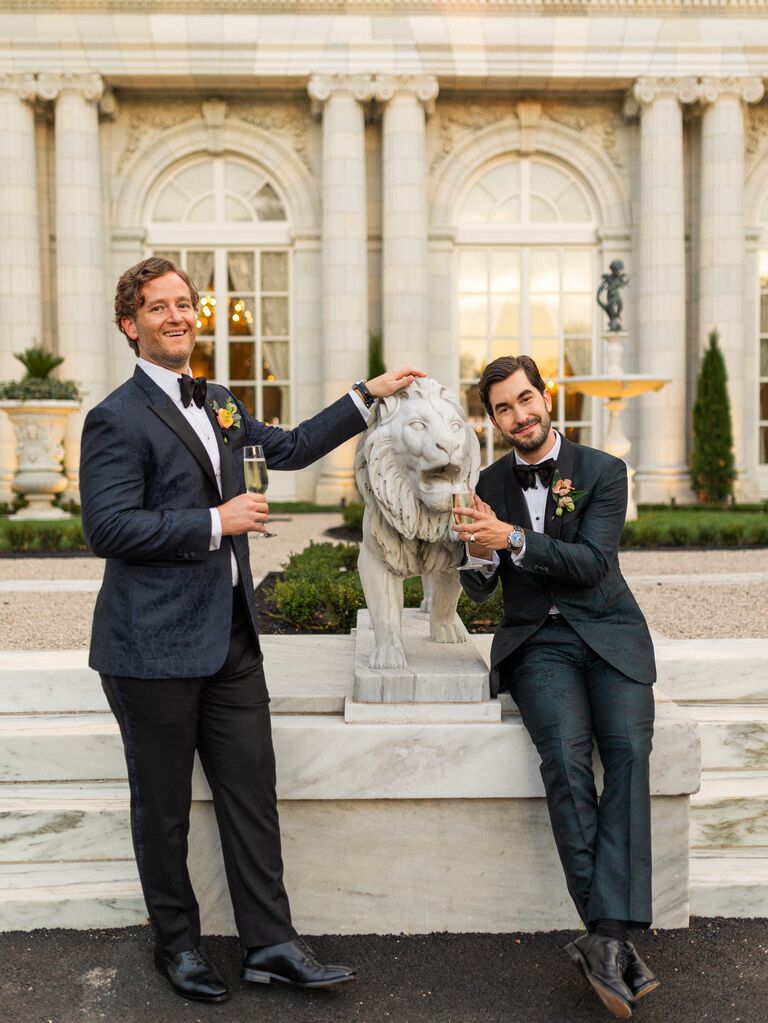 Whitaker Irvin and Michael Mendieta posing with lion statues outside Rosecliff Mansion