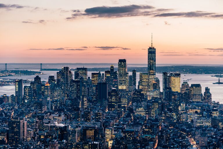 new york city skyline lower manhattan at sunset sublime lights on buildings and a pink sky with clouds