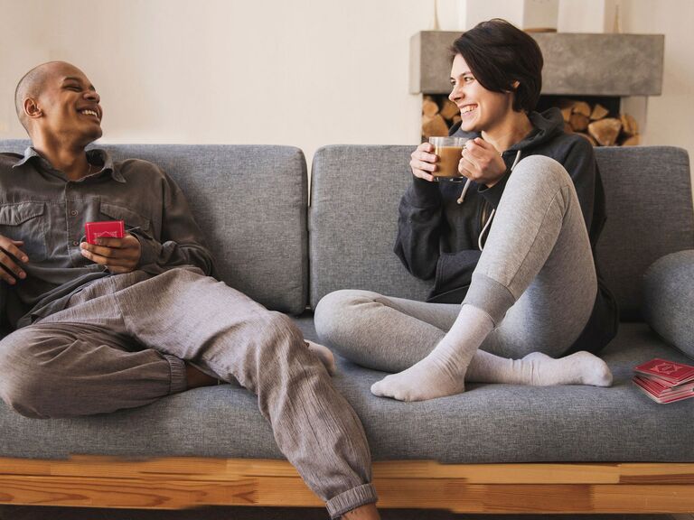 Couple playing relationship question card game on couch
