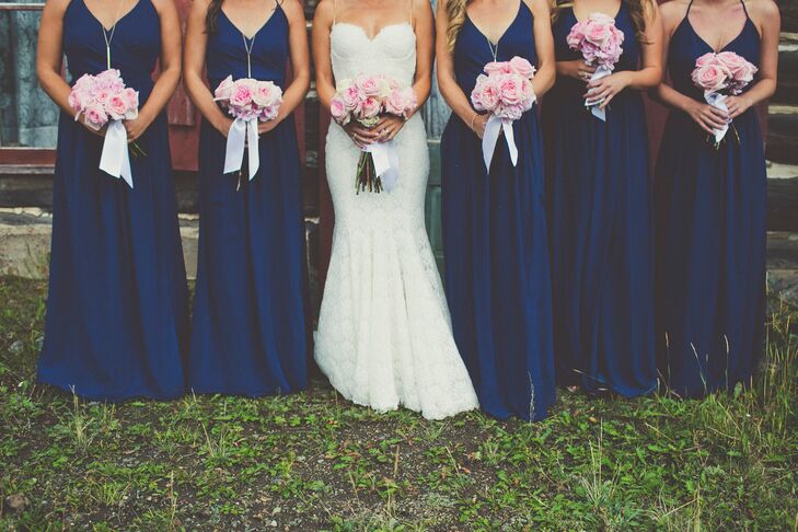 The bridesmaids wore floor-length navy Joanna August dresses with long gold necklaces and nude heels.