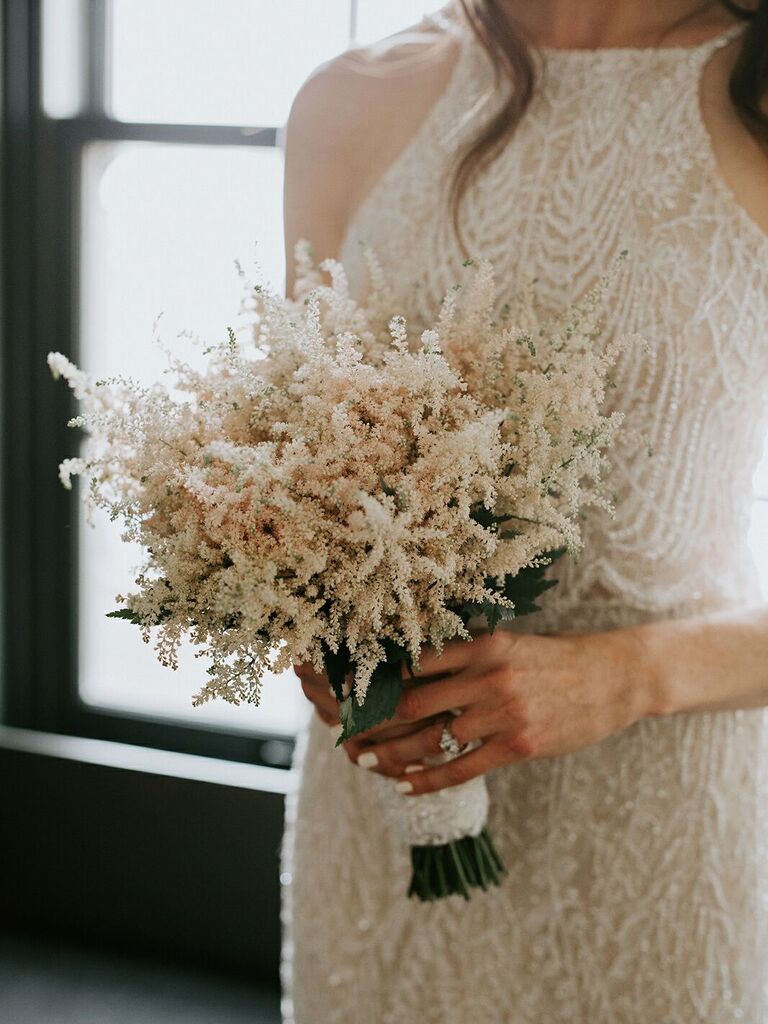 bride holding small simple wedding bouquet with blush and ivory astilbe